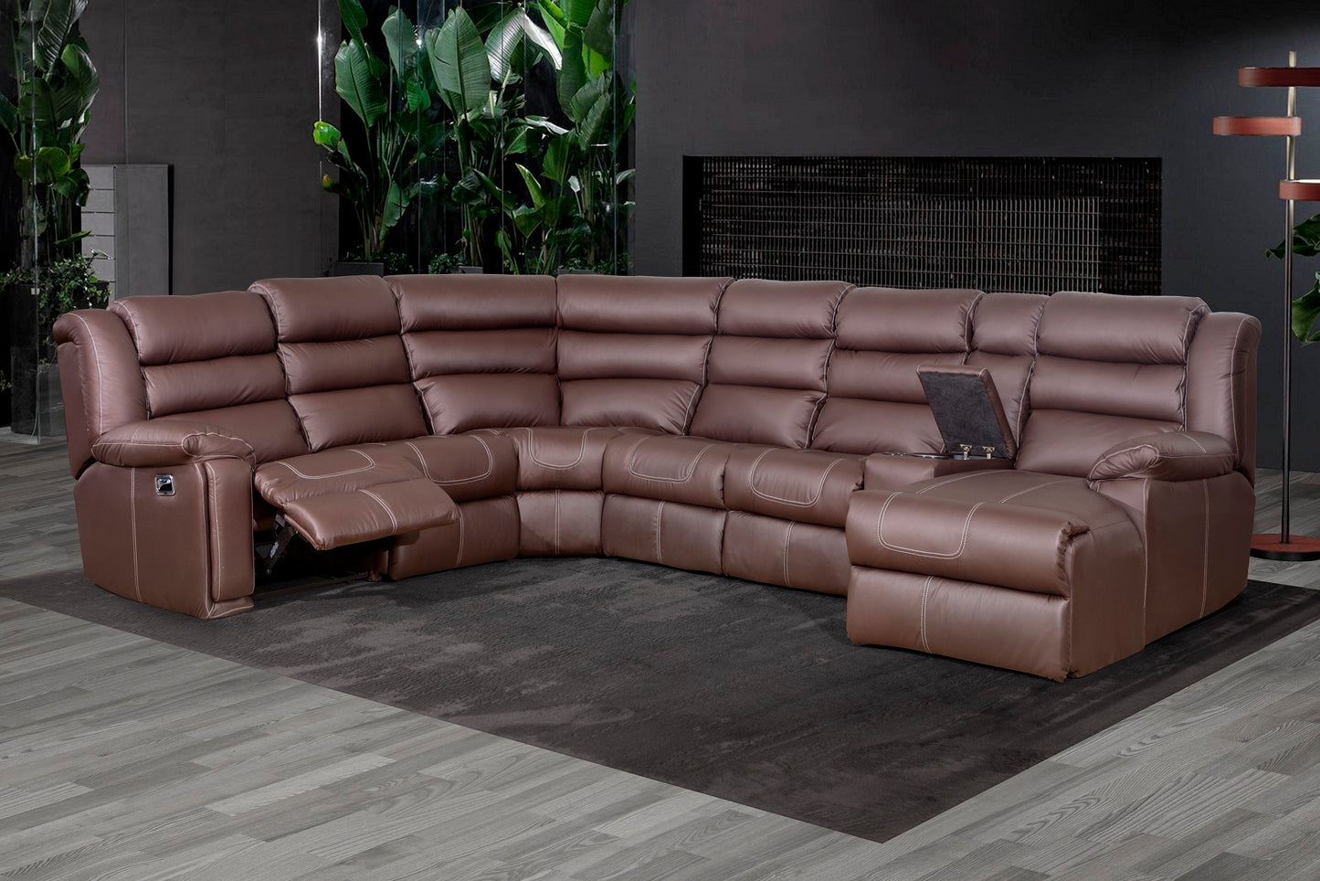 A brown leather corner sectional sofa with multiple recliner chairs and an ottoman, arranged in a large L-shape.