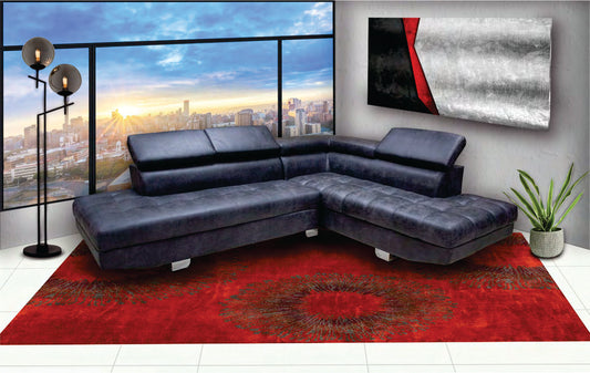 Modern living room with a blue sectional sofa, red rug, and cityscape view.