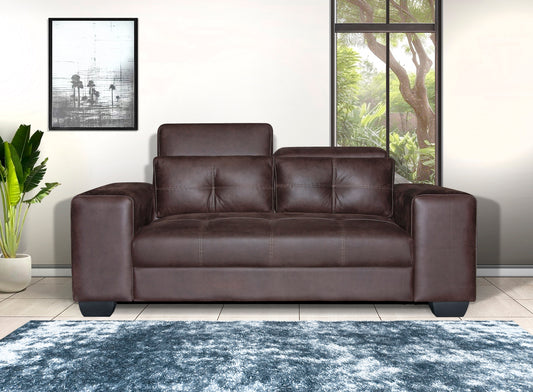 Brown leather sofa in a room with a rug and window.