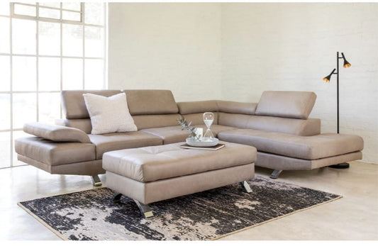 Beige sectional sofa in a living room setting with a rug and decor items.