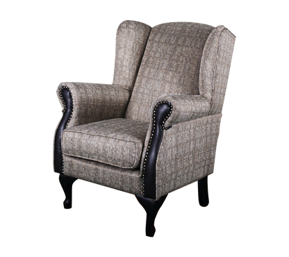 A traditional wingback chair with beige upholstery and black detailing, including nailhead trim and wooden legs with gold accents.